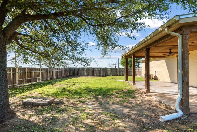 Fenced backyard with a ceiling fan and a patio area | Image 26