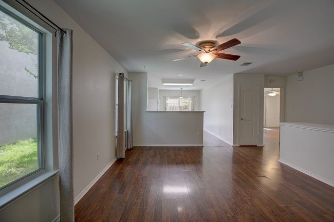 Main Family room with a ceiling fan, wood finished floors, and baseboards | Image 4
