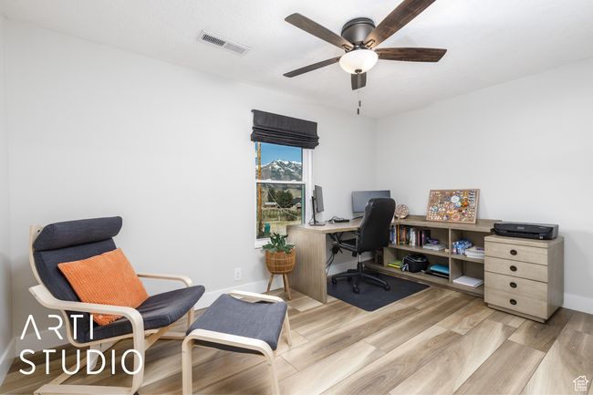 Office space featuring light wood-style floors, visible vents, a ceiling fan, and baseboards | Image 18
