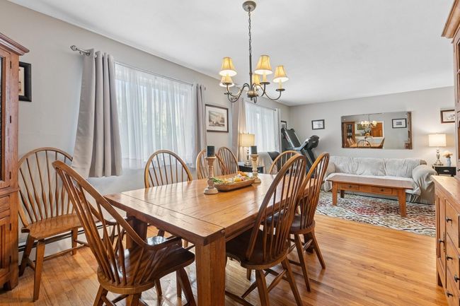 Dining area featuring a baseboard heating unit, light wood-type flooring, and an inviting chandelier | Image 9