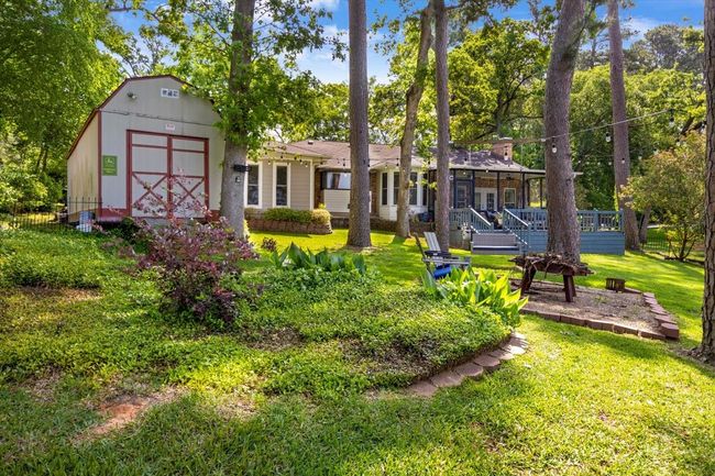 Back of property featuring a wooden deck, an outdoor structure, a shed, and a yard | Image 29