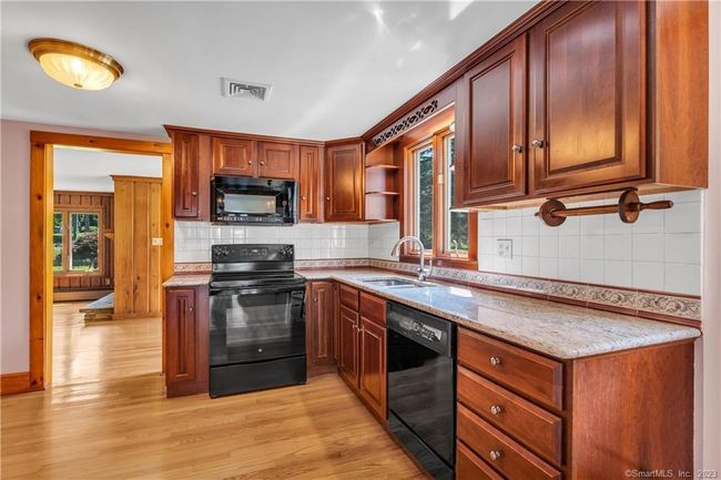 Renovated with cherry cabinets, granite counters, and tile back splash, the window over the sink faces south. | Image 8