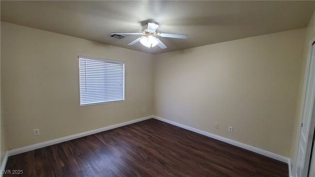 Empty room featuring dark wood finished floors, baseboards, visible vents, and ceiling fan | Image 16