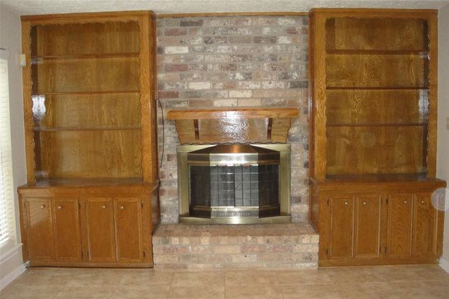 Gas or wood burning fireplace and stately bookshelves. | Image 5