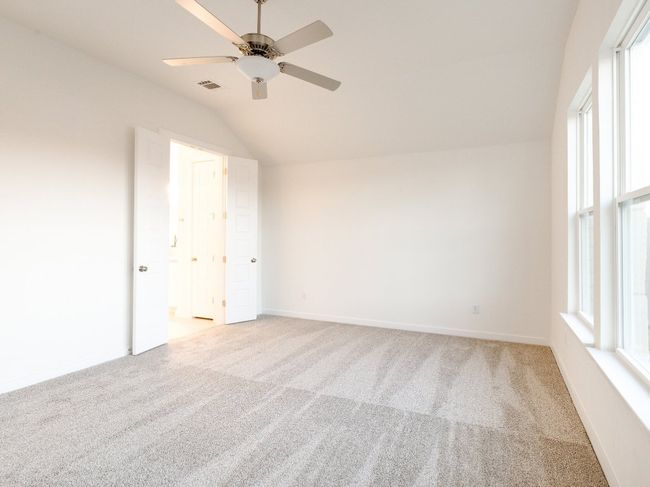 Empty room featuring vaulted ceiling, light carpet, a ceiling fan, and healthy amount of natural light | Image 31