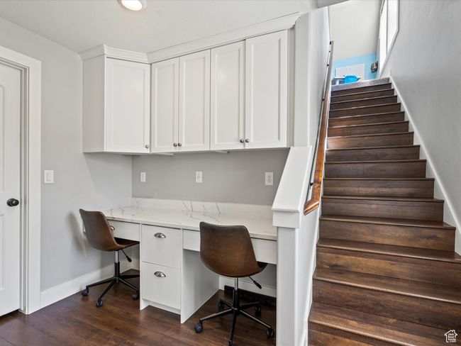 Home office with built in study area, baseboards, and dark wood finished floors | Image 22