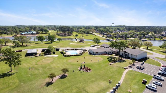 Drone / aerial view of a large body of water, a tree filled landscape, and a golf club | Image 26