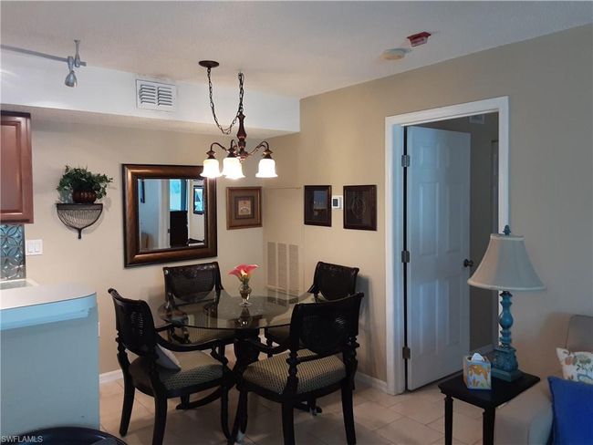 Dining room with baseboards, chandelier, and light tile patterned flooring | Image 8