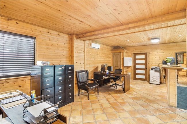 Office featuring wood walls, wood ceiling with exposed beams, and a wall mounted AC | Image 18