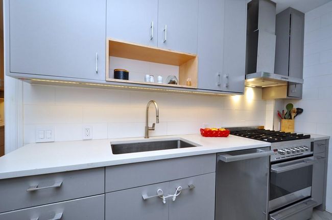 Renovated kitchen has custom cabinets, stainless steel appliances including a stove, dishwasher and steam oven. The refrigerator has matching cabinet door. Other features include a quartz counter, pantry, walk-in closet, under cabinets lighting and herringbone tile floor. | Image 11