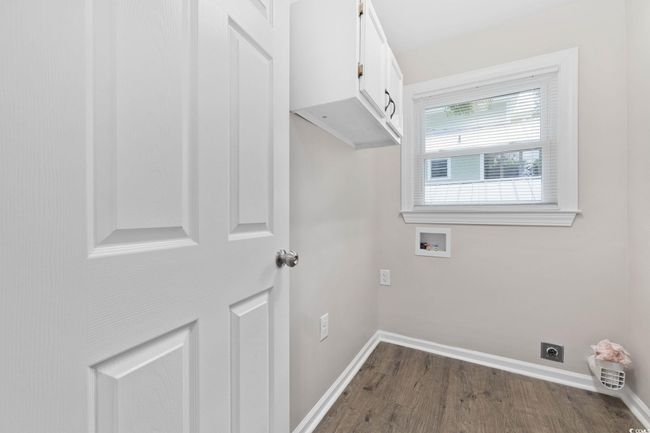 Laundry room featuring cabinet space, hookup for a washing machine, hookup for an electric dryer, dark wood-style flooring, and baseboards | Image 22