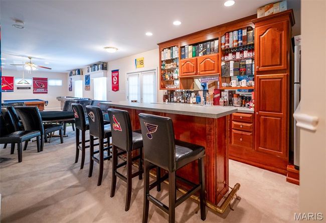 Indoor dry bar with light colored carpet, a ceiling fan, plenty of natural light, and recessed lighting | Image 49