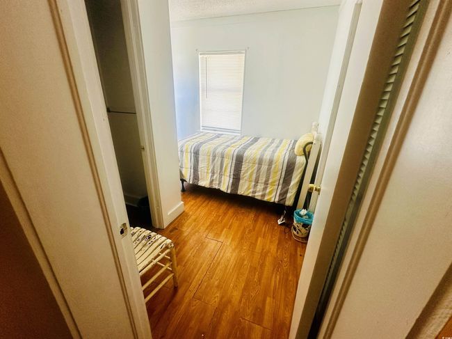 Bedroom with wood finished floors and a textured ceiling | Image 9