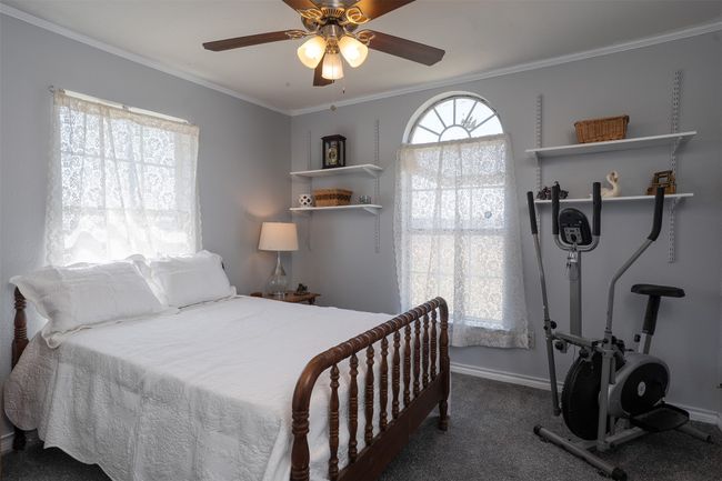 Bedroom with crown molding, baseboards, a ceiling fan, and carpet floors | Image 23