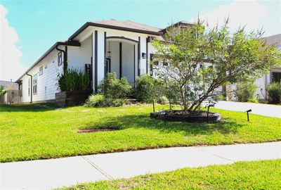 Welcome to this charming home with excellent curb appeal. The front of the home features thoughtfully arranged plants that add warmth and vibrancy to the entryway, creating a welcoming atmosphere! | Image 1