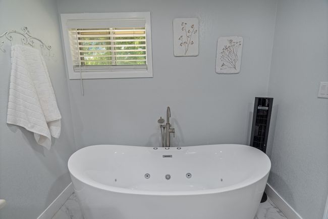 Full bath with marble look tiles and a freestanding tub | Image 19
