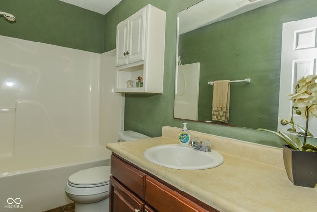 bathroom featuring toilet, vanity, and tub / shower combination | Image 10