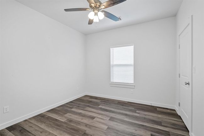 Unfurnished room with ceiling fan and dark wood finished floors | Image 6