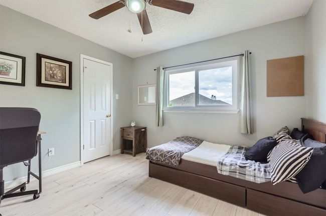 Bedroom with light wood-style flooring, a ceiling fan, and baseboards | Image 20