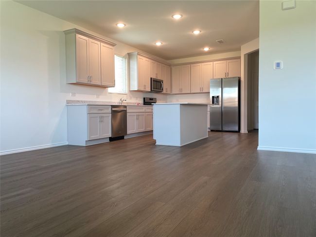 Kitchen featuring appliances with stainless steel finishes, light countertops, baseboards, dark wood-type flooring, and recessed lighting | Image 8