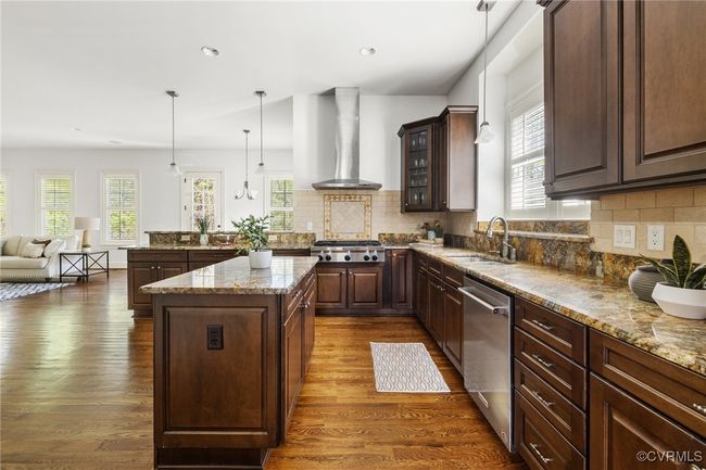 10' Ceilings, Surround sound, Island with storage, Kitchen Aid 5 burner gas range, Kitchen aid wall oven, Whirpool wall microwave, Kitchen aid stainless steel refrigerator and dishwasher, Granite countertops, Recessed and pendant lighting, Double bowl stainless sink, corner pantry, decorative tile behind the range, tile backsplash, bar seating. | Image 9