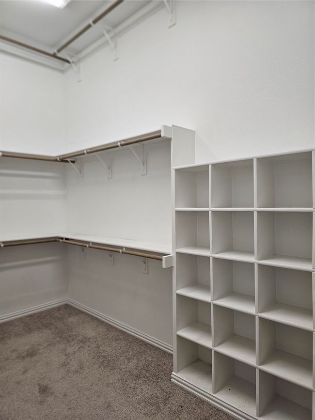 Walk in closet with dark colored carpet | Image 12