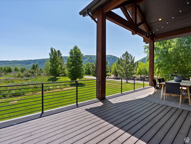 Deck featuring a mountain view and outdoor dining area | Image 48