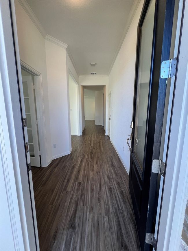 Hall with dark wood-type flooring and crown molding | Image 6