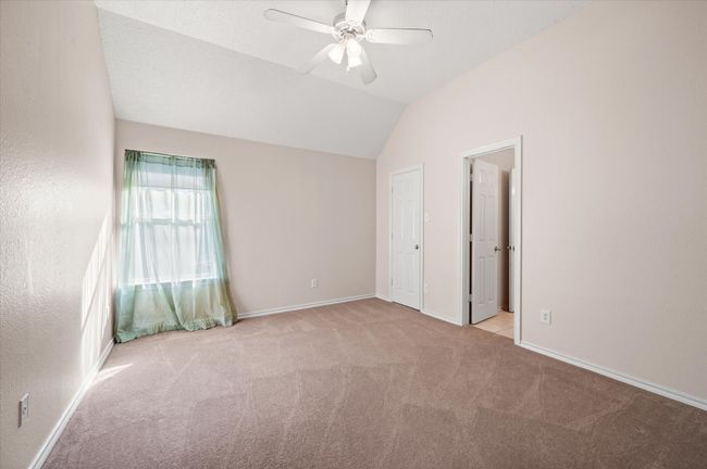 Secondary bedroom with vaulted ceiling, walk-in closet and flexible space for furniture arranging. | Image 36