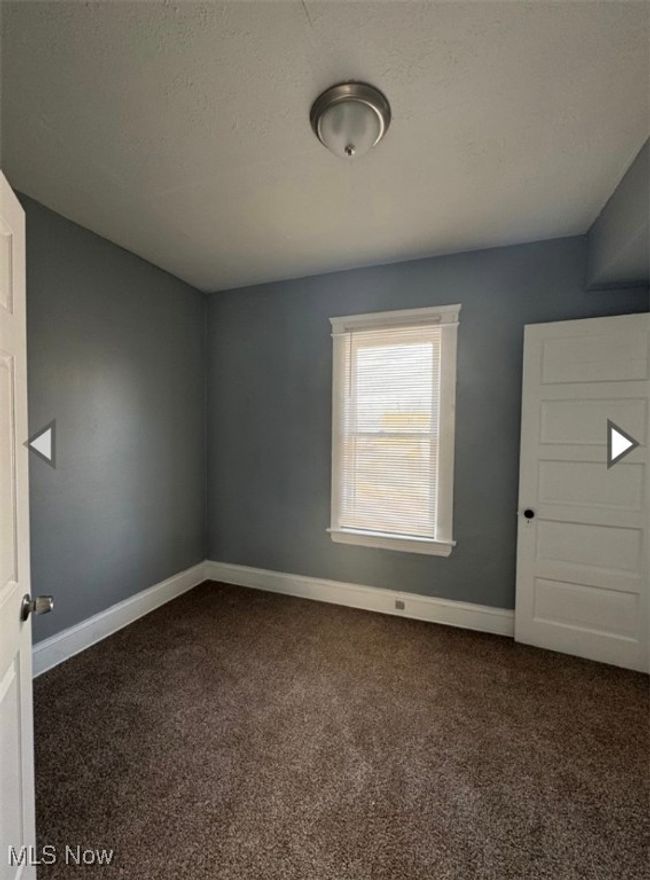 Spare room featuring dark carpet and a textured ceiling | Image 8