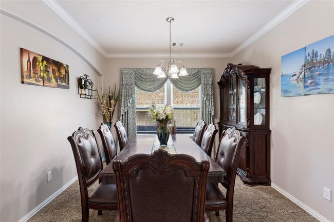 Elegant dining room with ample natural light, for a cozy dining experience. | Image 5