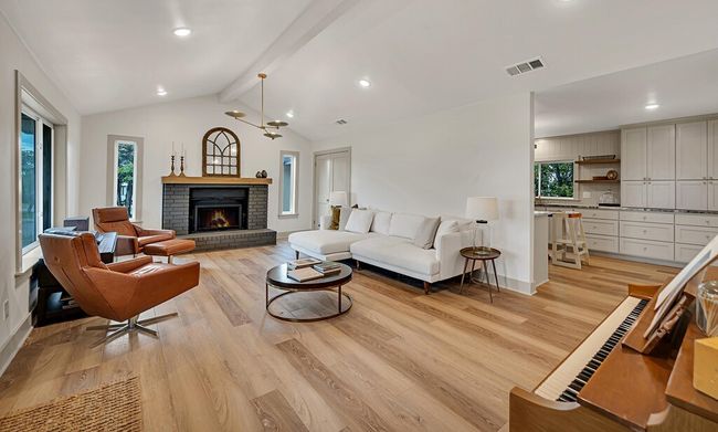 Living area featuring plenty of natural light, light wood-type flooring, a brick fireplace, and recessed lighting | Image 6