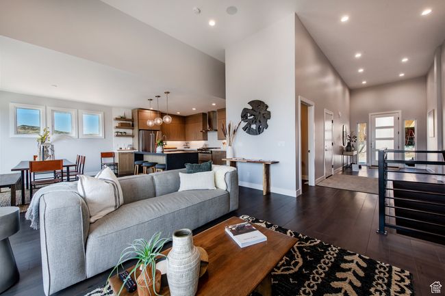 Living room featuring a high ceiling and dark hardwood / wood-style floors | Image 15