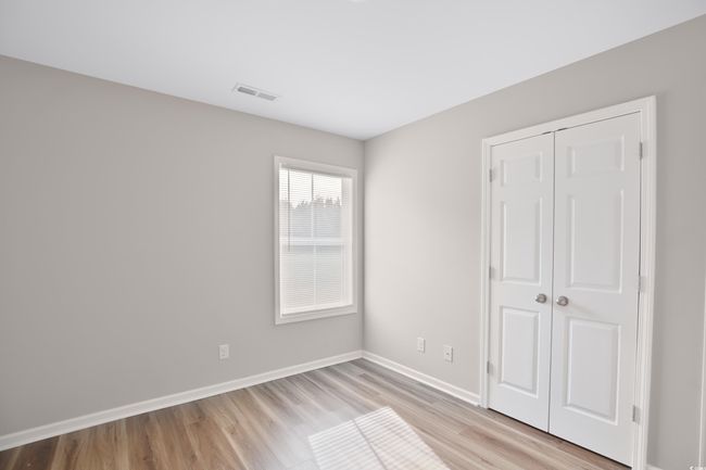 Unfurnished bedroom with light wood-type flooring and a closet | Image 5