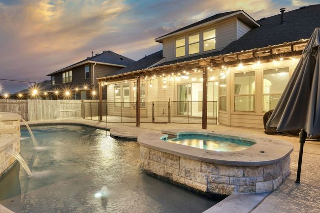Rear view of property with large covered patio, pool and hot tub | Image 28