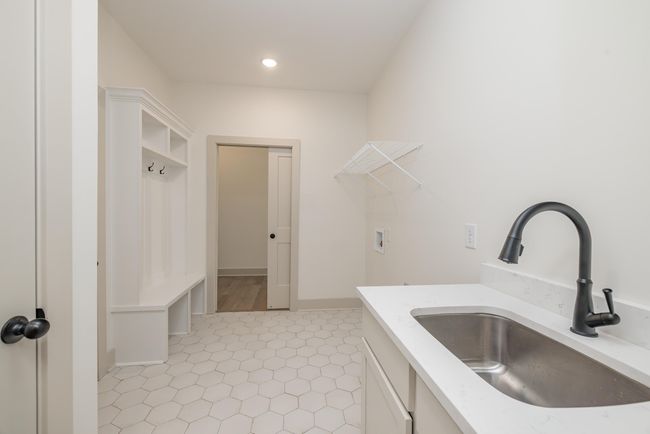 Laundry Room with Full Sink Cabinet, Mud bench, and direct primary suite access | Image 23