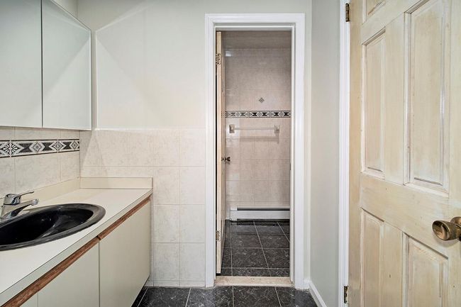 Bathroom featuring tile walls, vanity, and a baseboard radiator | Image 21