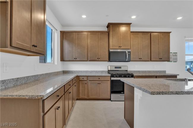 Kitchen featuring recessed lighting, light stone counters, appliances with stainless steel finishes, and a sink | Image 10