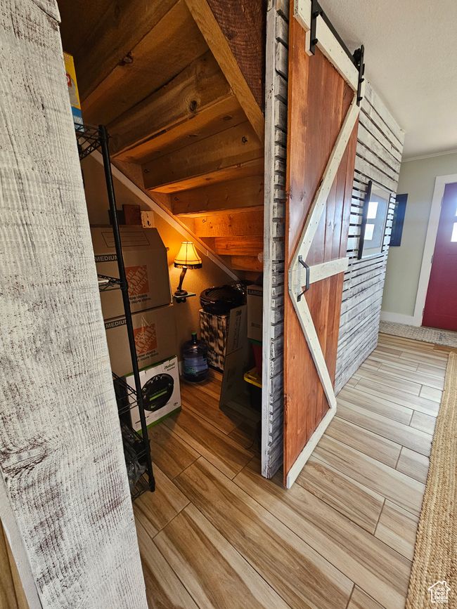 Bonus storage room featuring a barn door and wood finished floors | Image 38