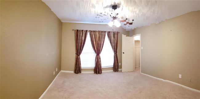 Large primary ensuite bedroom with a pool view. Huge walk-in closet. Ceiling fan for added comfort. | Image 8