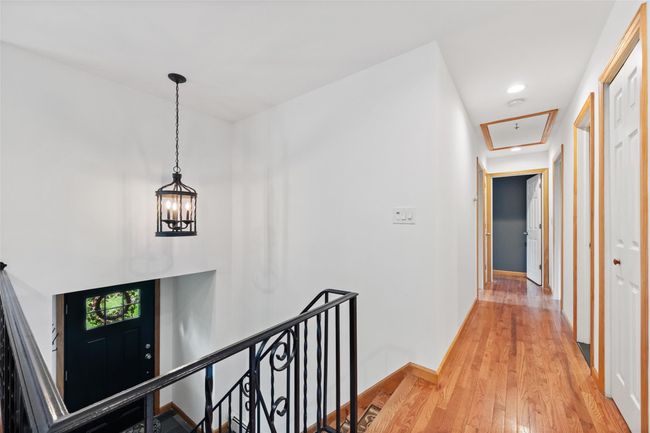 Hallway with light wood-style flooring, an upstairs landing, baseboards, attic access, and recessed lighting | Image 7