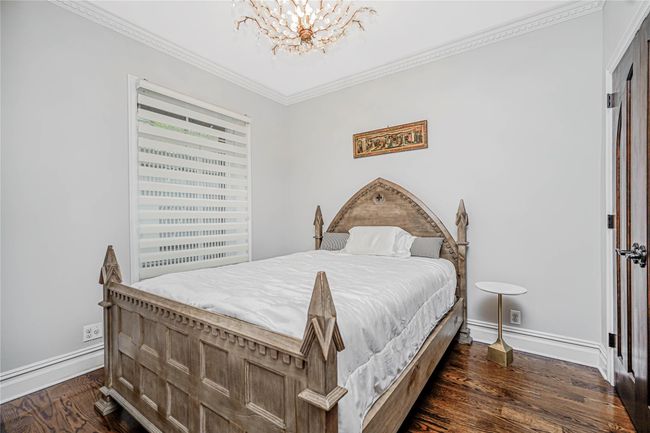 Bedroom with a chandelier, dark wood-style flooring, and crown molding | Image 22