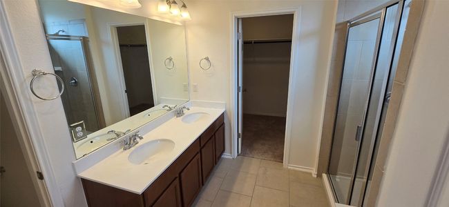 Bathroom featuring a spacious closet, double vanity, a shower stall, and tile patterned floors | Image 18