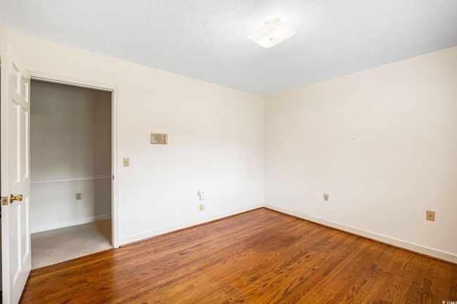 Spare room featuring wood finished floors and baseboards | Image 17