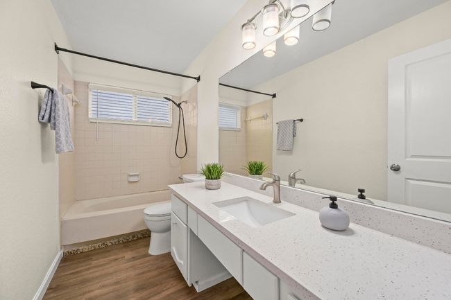 This full bath, located adjacent to the secondary room, features quartz countertops. | Image 15