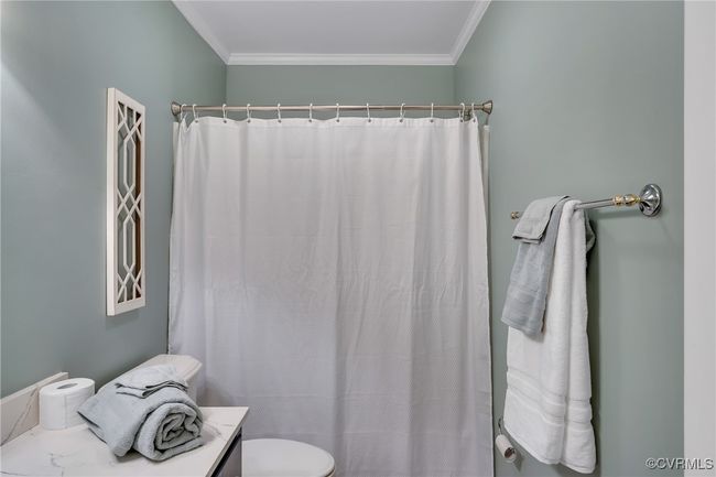 Bathroom with vanity, crown molding, and curtain with tub and shower | Image 25