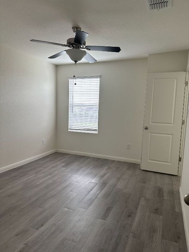 Spare room with wood finished floors, a ceiling fan, and a textured ceiling | Image 15