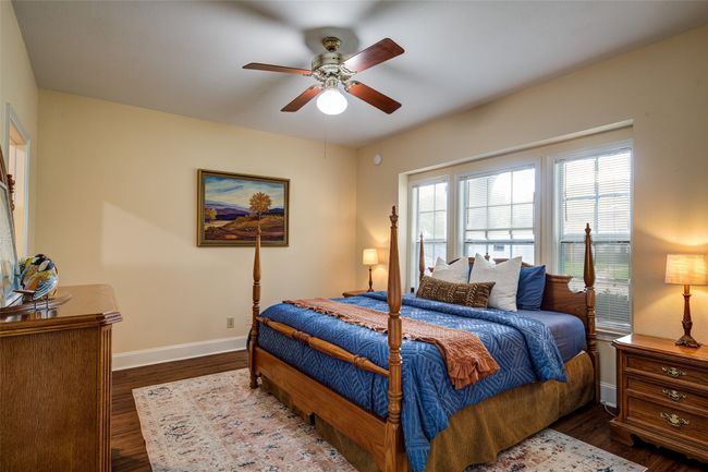Bedroom with wood finished floors and ceiling fan | Image 16