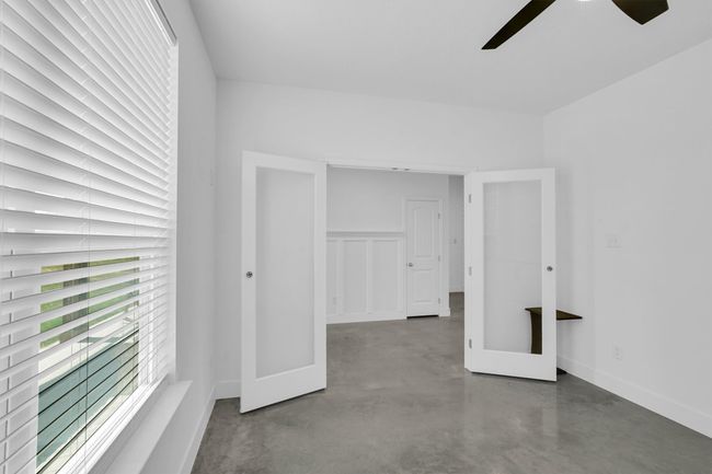 Unfurnished bedroom featuring finished concrete flooring, baseboards, and a ceiling fan | Image 14