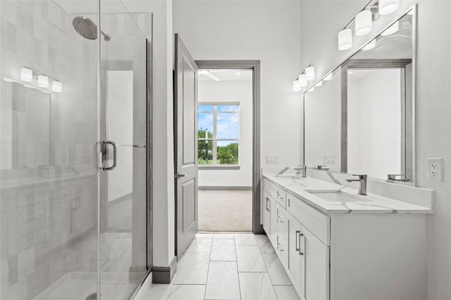 Bathroom featuring double vanity, a stall shower, and marble look tile flooring | Image 23